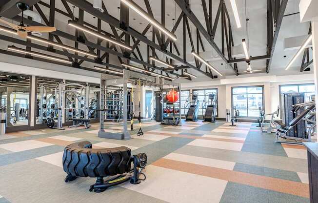 A gym with a variety of equipment and a tire on the floor.