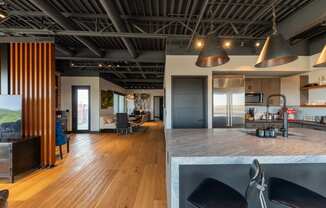 the kitchen and living room of a modern house with wood floors and a gray counter