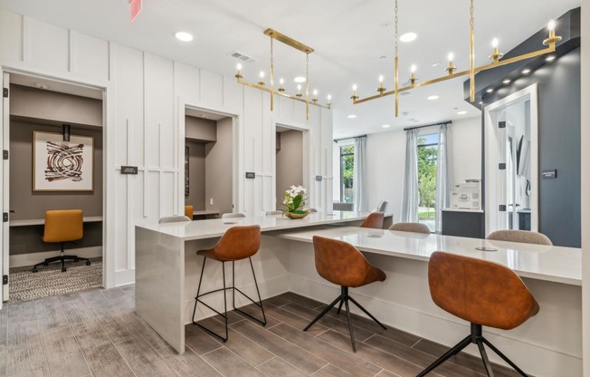 a kitchen with a long counter top and chairs