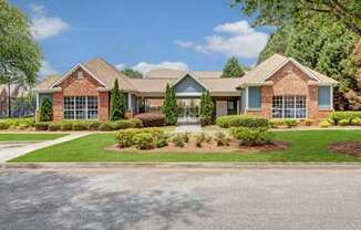 A house with a brick facade and a green lawn in front.