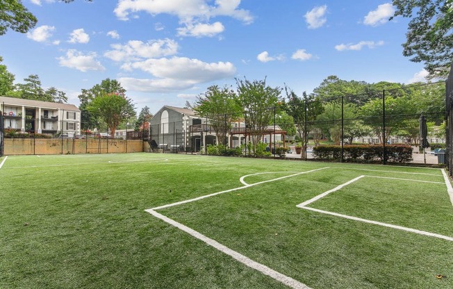 A tennis court surrounded by a fence and trees.