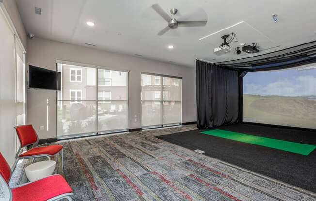 a room with a projector screen and chairs and a large window