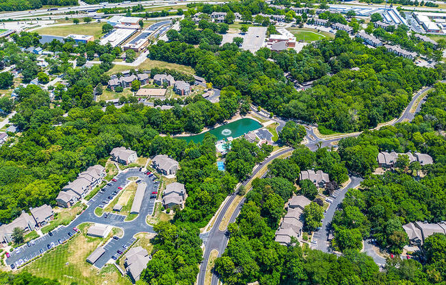 aerial view of apartment buildings and parking with trees