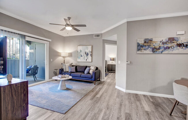 a living room with a couch and a ceiling fan