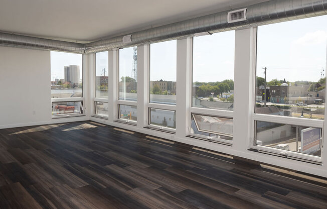 a living room with a large window and hardwood floors at The Landing at 1001 NP, Fargo, ND 58102