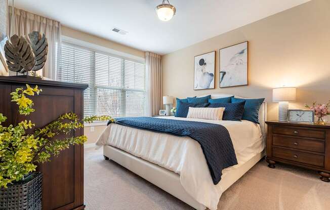A bedroom with a large bed and a wooden cabinet.