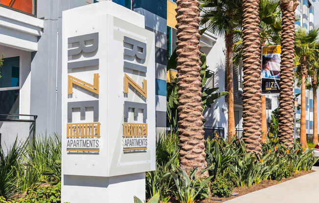A sign for Rize Apartments is displayed in front of some palm trees.