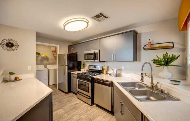 a kitchen with stainless steel appliances and white countertops