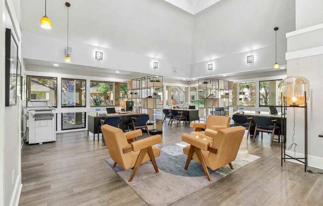 a living room with chairs and tables and a library at Summerwood Apartments, Santa Clara, CA