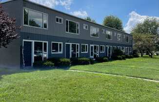 a gray building with green grass in front of it