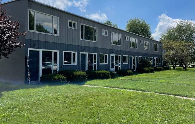 a gray building with green grass in front of it