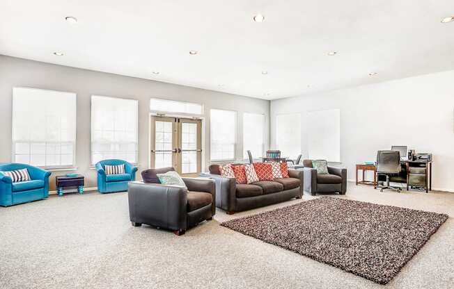 Clubhouse Lounge with Armchairs and Kitchen with Wood Cabinets and Stainless Steel Appliances