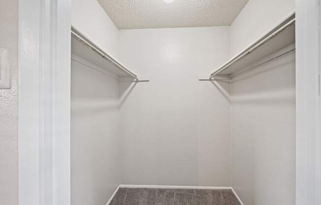 a walk in closet in a bedroom with white walls and a white ceiling