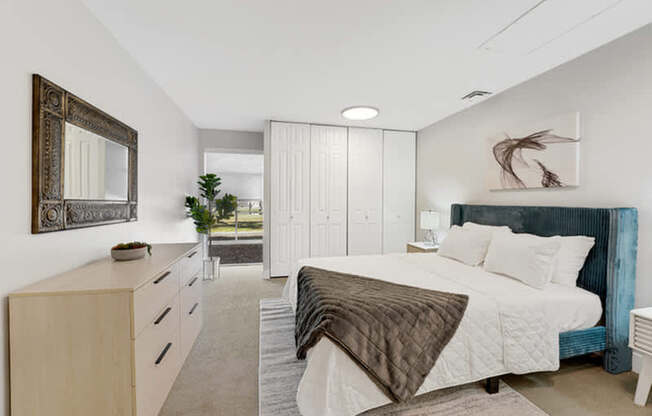 A bedroom with a large bed and a mirror on the wall.