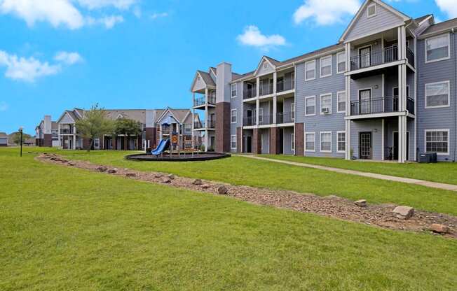 an exterior view of an apartment building with a playground