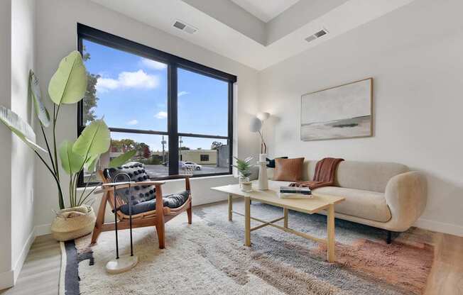 A living room with a couch, chair, and a large window.