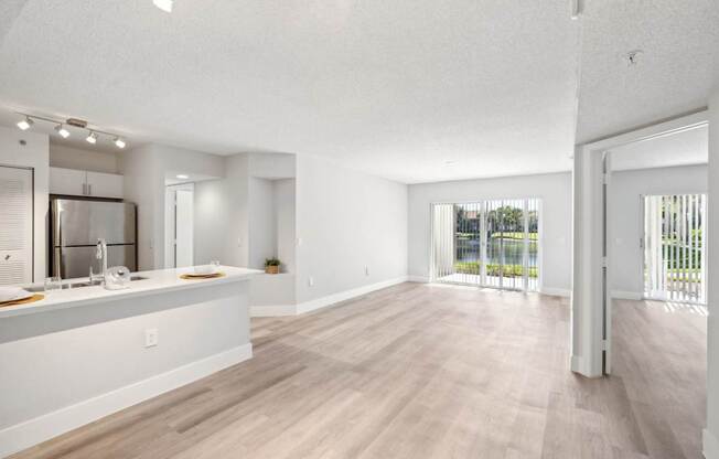 A spacious kitchen with white cabinets and a wooden floor.