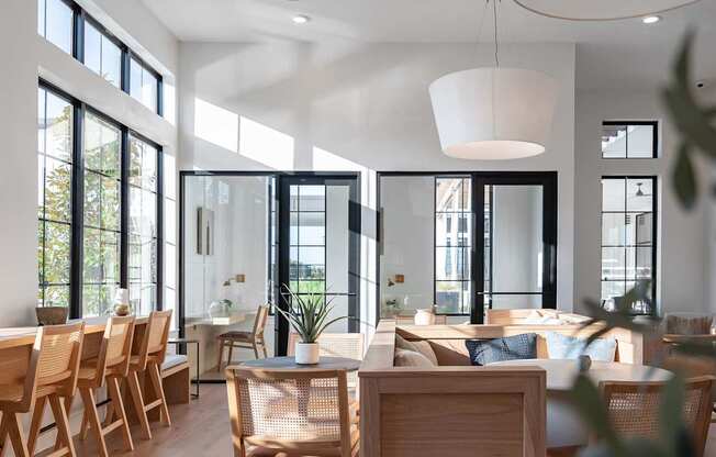 A modern dining room with wooden chairs and a white pendant light.