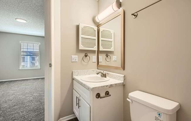 A bathroom with a white sink and toilet.