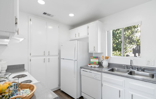 a kitchen with white cabinets and a sink and a refrigerator