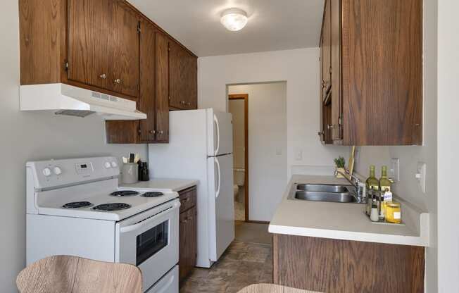 a kitchen with white appliances and wooden cabinets