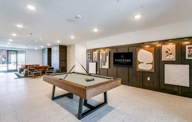 A pool table in a room with a sign that says "TAPESTRY".