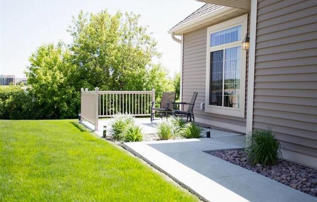 Private patio at Cascade Shores Townhomes with a paved walkway and a lush lawn.