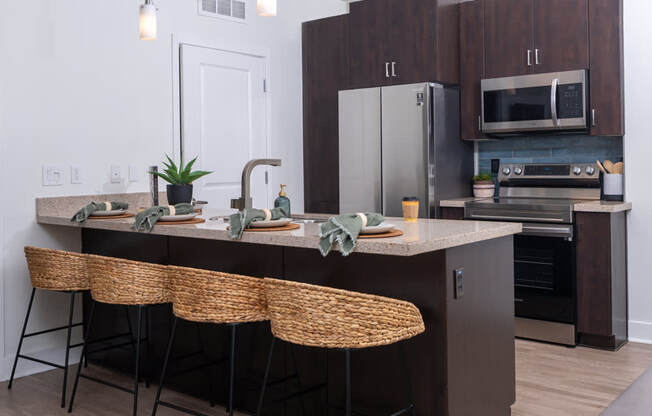 A kitchen with a counter and chairs.
