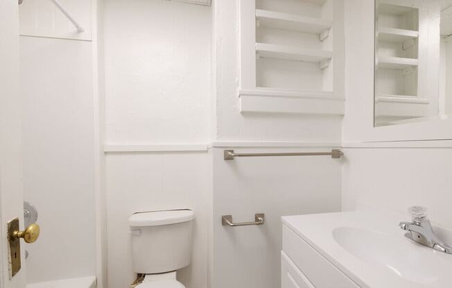 a white bathroom with a toilet and a sink