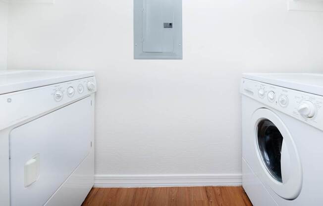 A white washing machine and dryer in a laundry room.