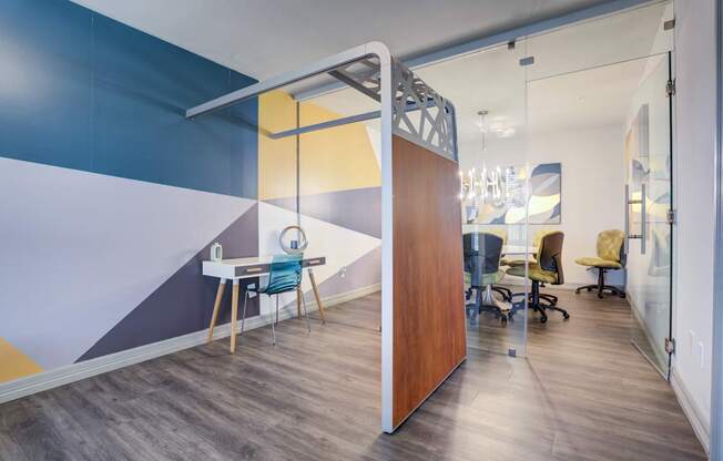 A room with a blue and yellow wall and a wooden table with chairs.