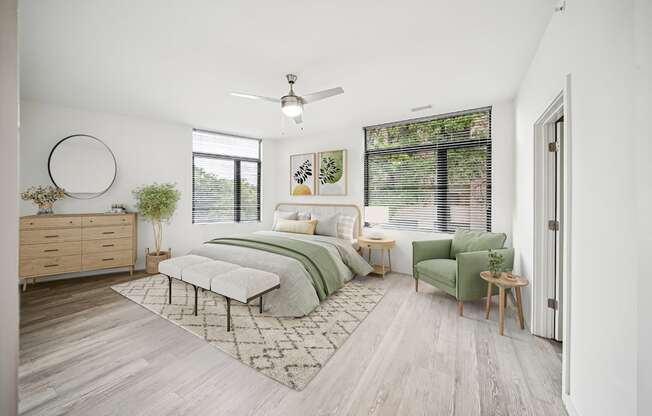 A bedroom with a bed, chair, and a plant.