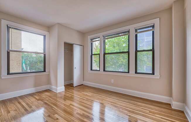 an empty living room with wood floors and windows