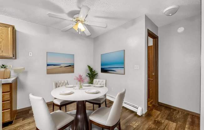 a dining room with a table and chairs and a ceiling fan at Creekstone Falls, Sioux Falls