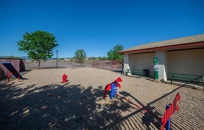 two red fire hydrants in a fenced in play area with a building