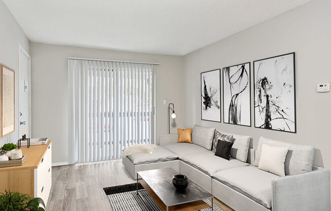 Model Living Room with Wood-Style Flooring and Patio Accessibility at Seven Lakes at Carrollwood Apartments in Tampa, FL.