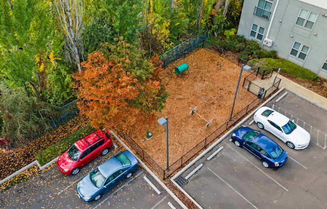 A parking lot with cars and a playground.