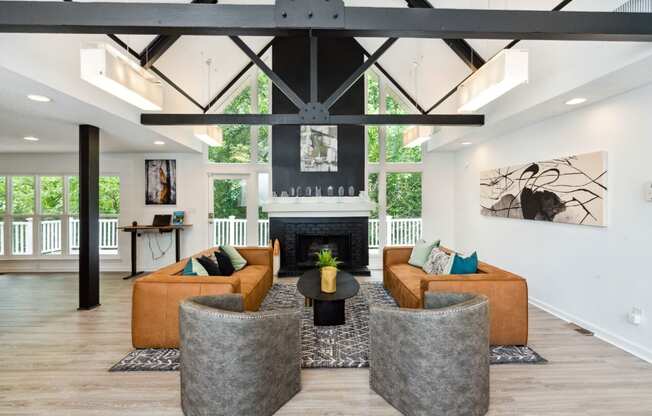 a living room with couches and chairs in front of a fireplace