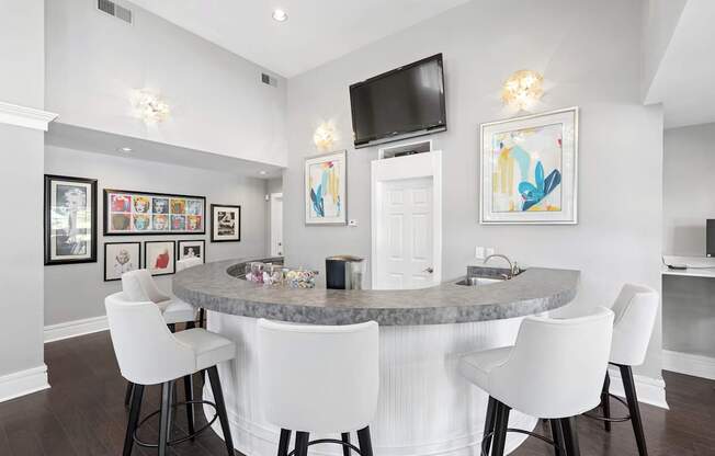 A modern dining room with a round table and white chairs.