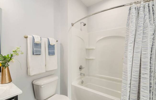 A white bathroom with a toilet, sink, and bathtub.