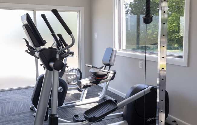 a home gym with exercise equipment and a window