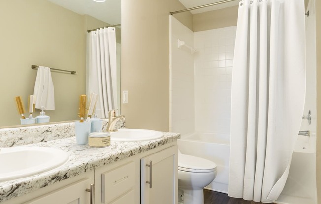 a bathroom with two sinks and a toilet and a shower