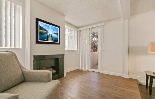 Living room with cozy fireplace, wood inspired floors, balcony or patio on the right, vertical blinds