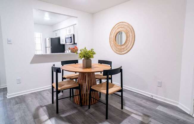 A dining room with a round table and chairs.