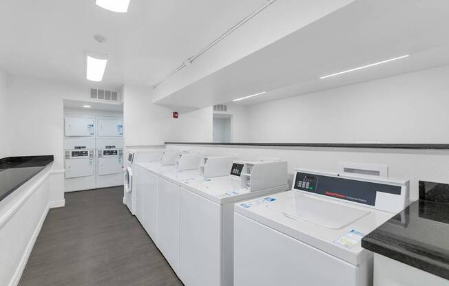A row of white washing machines in a laundromat at Urban WalkApartments on 6th Avenue, Arizona