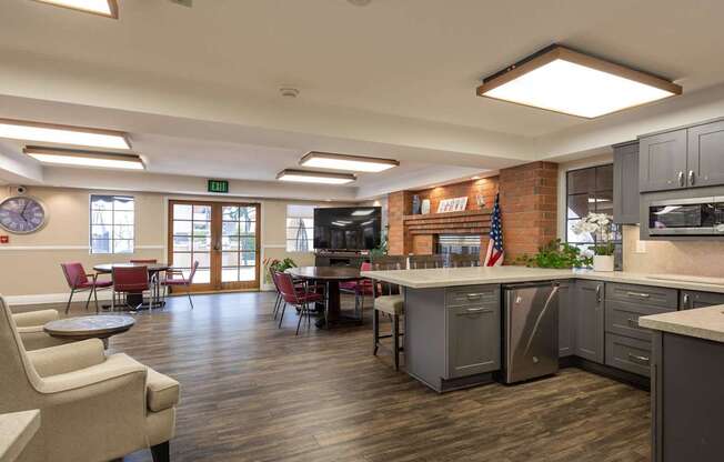 a clubhouse with a kitchen and a living room with a table and chairs at Huntington Terrace North Senior, California, 92648