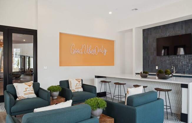 A living room with a green couch and a sign that says "Good Vibes Only".