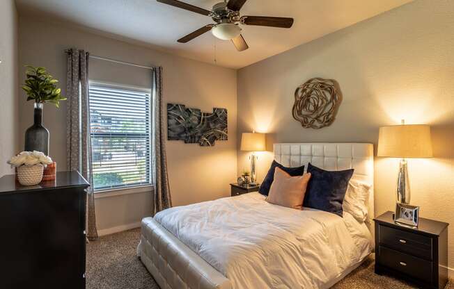 a bedroom with a large bed and a ceiling fan