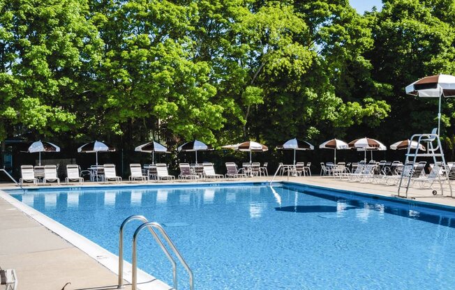 outdoor pool with lounge chairs and umbrellas at Hillcrest Village, Holbrook, NY