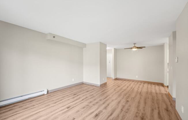 a living room with a hard wood floor and white walls